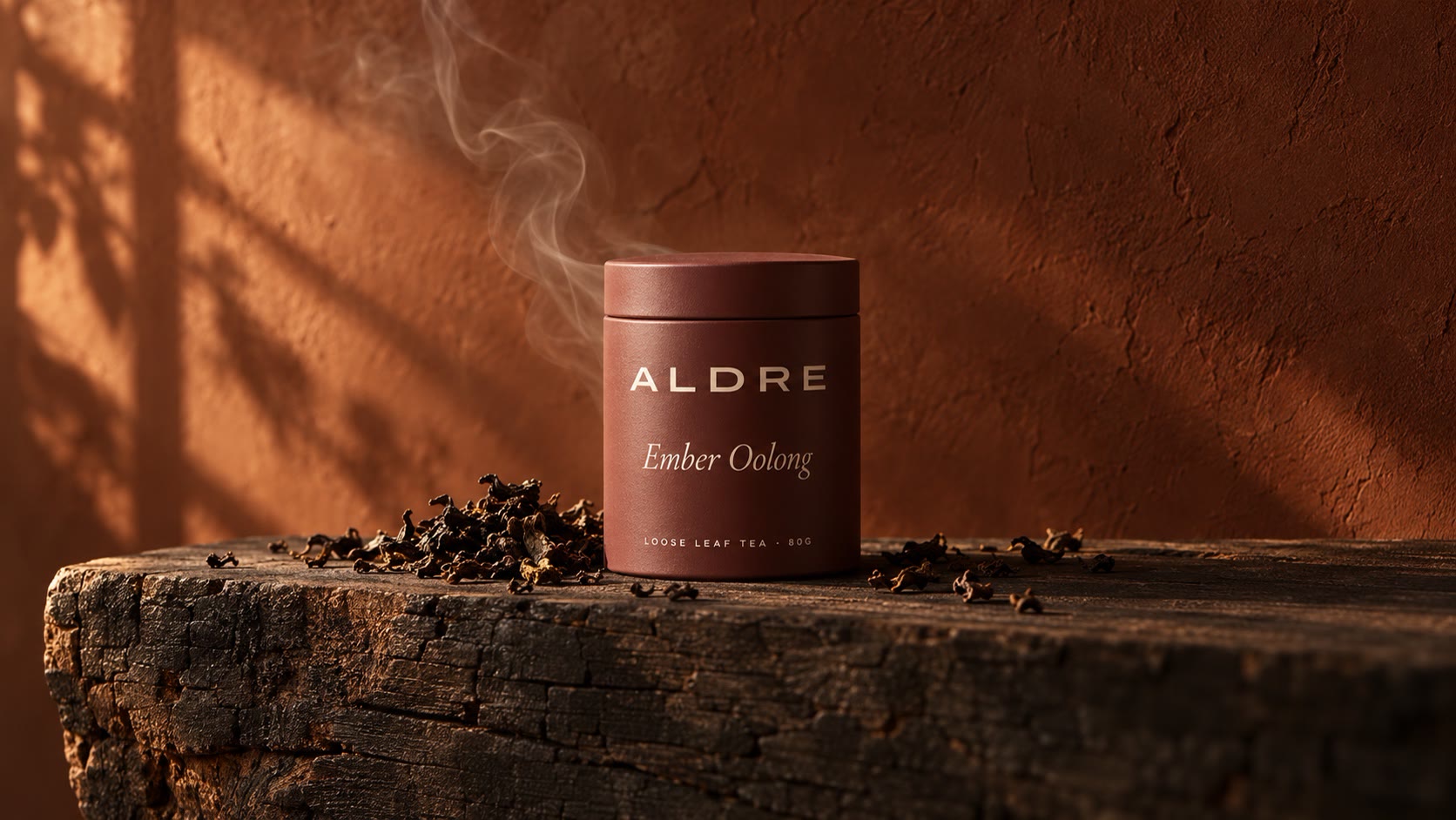 An oxblood tin on charred wood with a curl of smoke