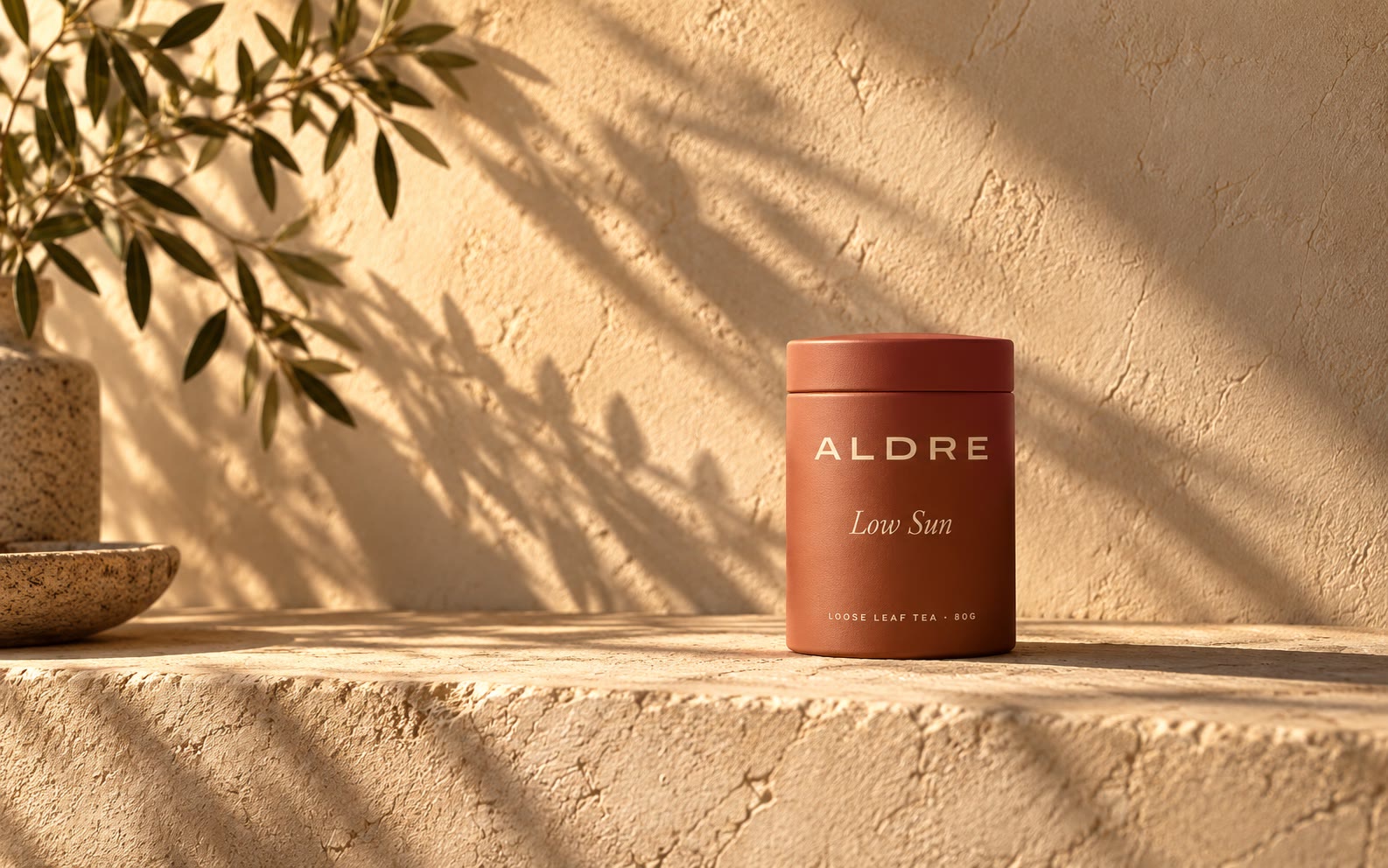 A terracotta tin on a sunlit clay plinth with a long shadow