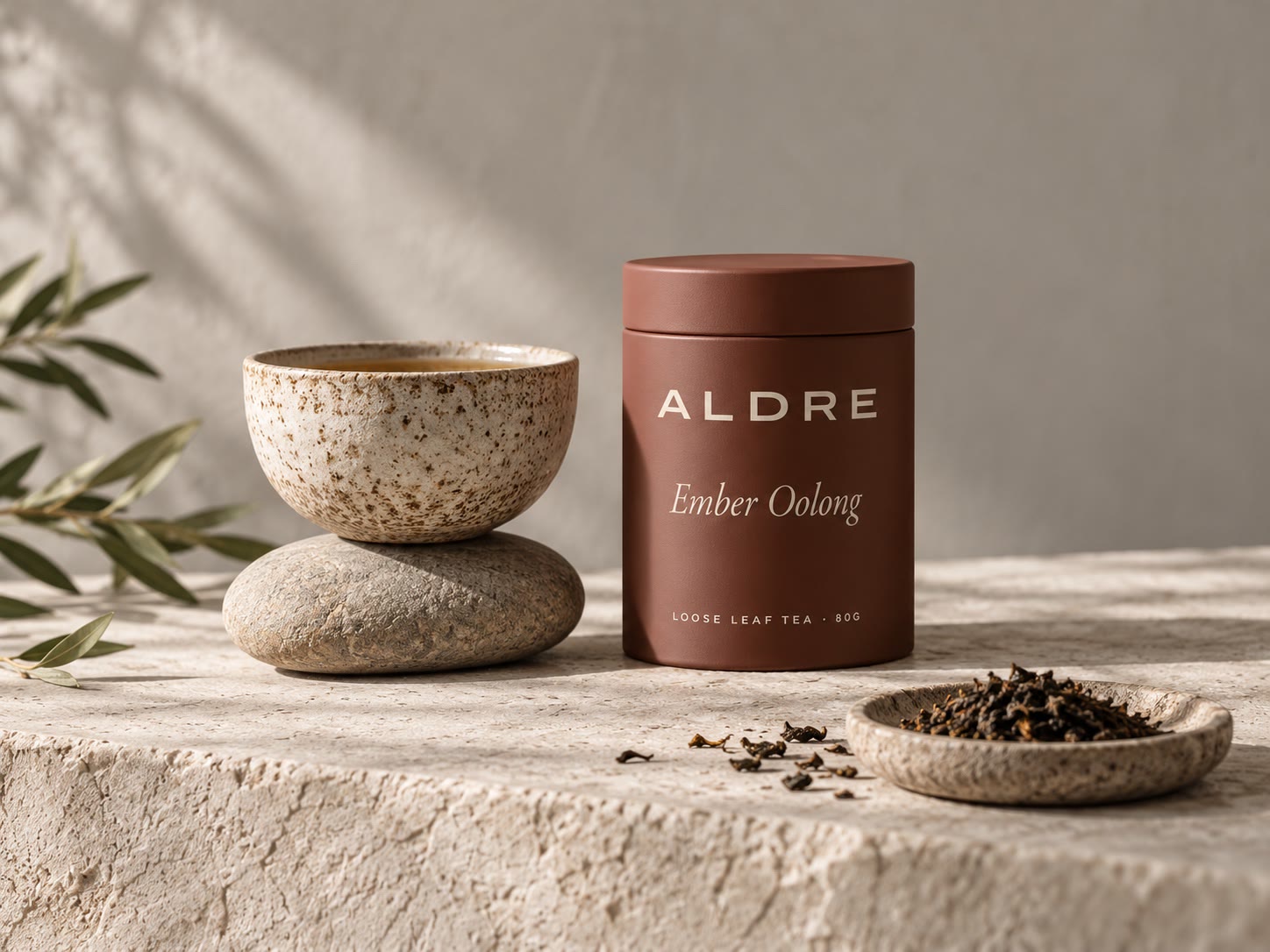 A speckled stoneware cup balanced on a river stone
