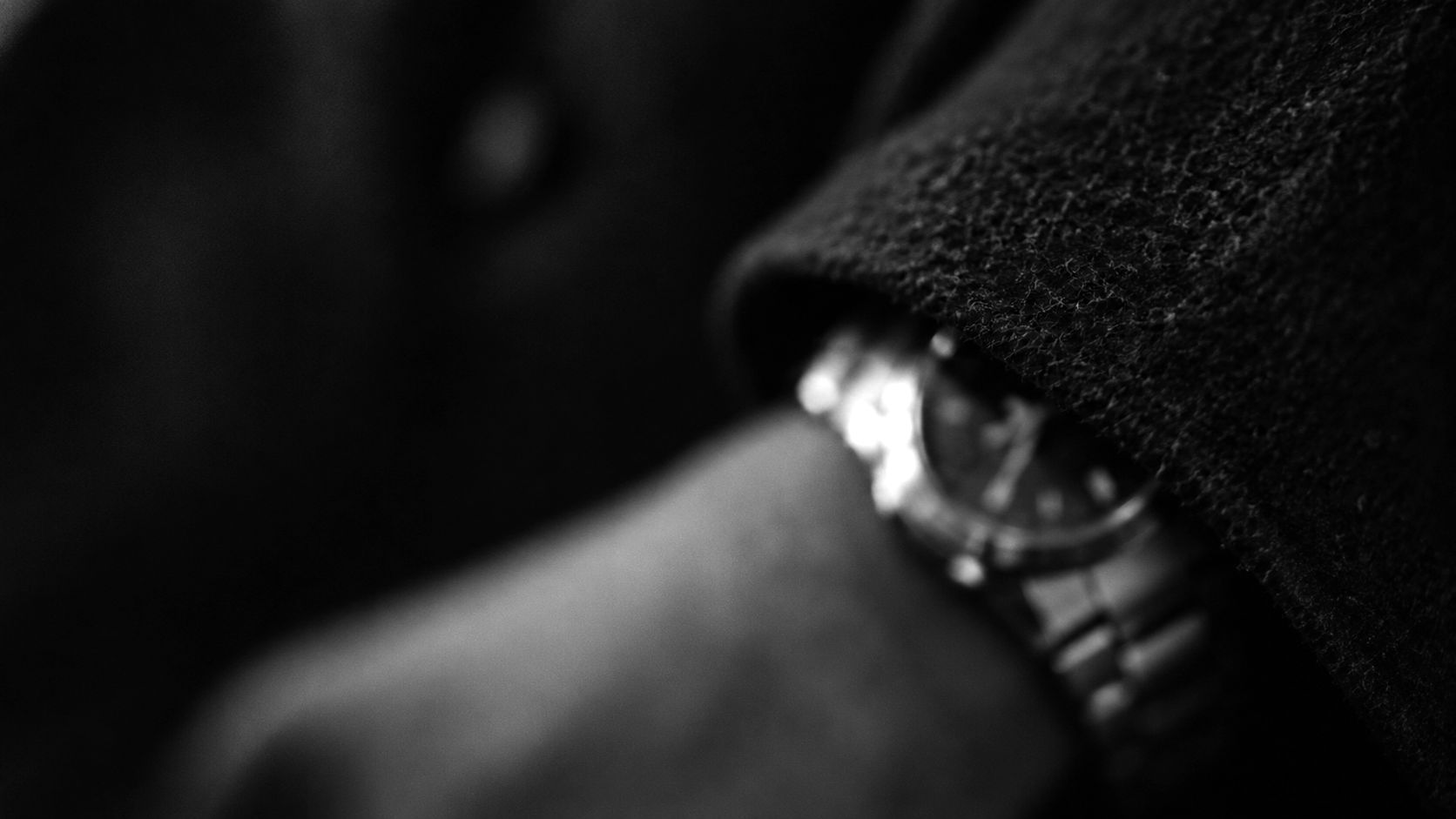 Dark wool sleeve with a watch at the cuff, out of focus