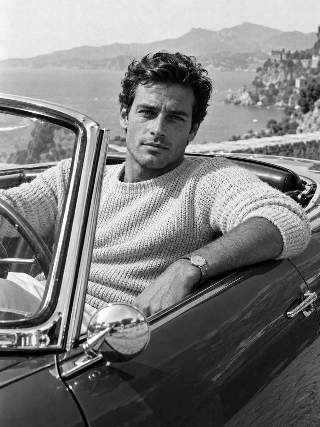 Man in a knit sweater at the wheel of a vintage open-top car