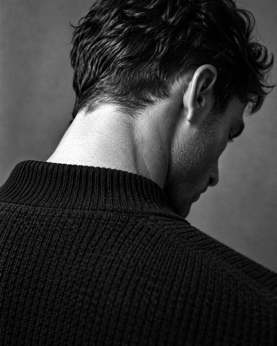 Back of a man's neck above a dark knit collar